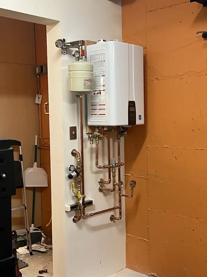Plumbing technician inspecting water heater connections in Lower Saucon